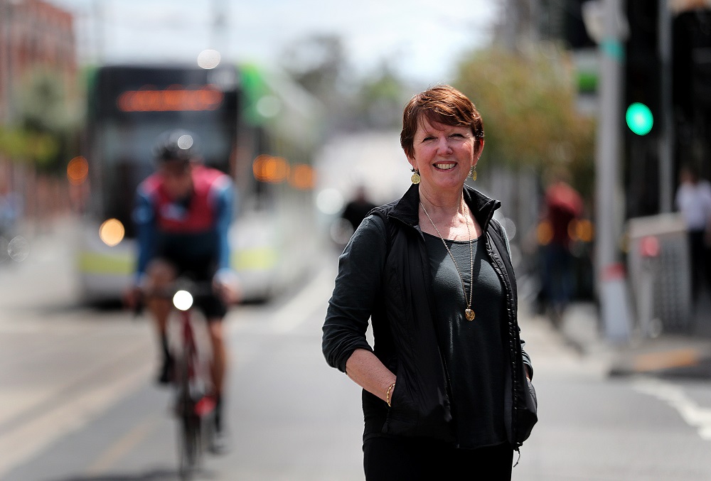 Image of Professor Billie Giles Corti in front of a Melbourne cityscape