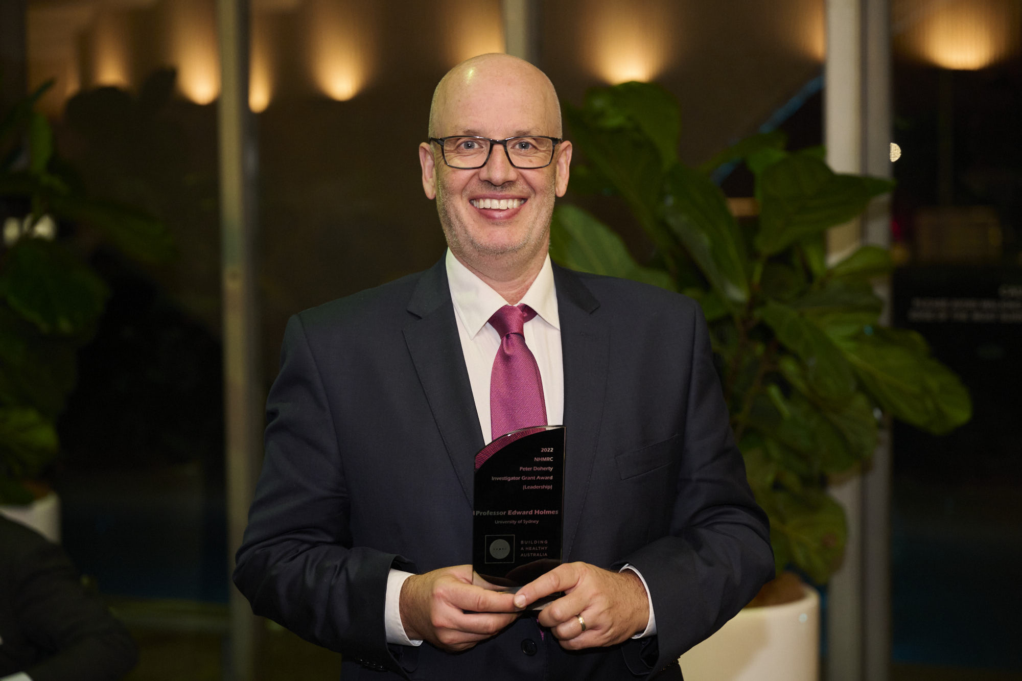 Professor Holmes at NHMRC’s Research Excellence Awards. Man holding award and smiling