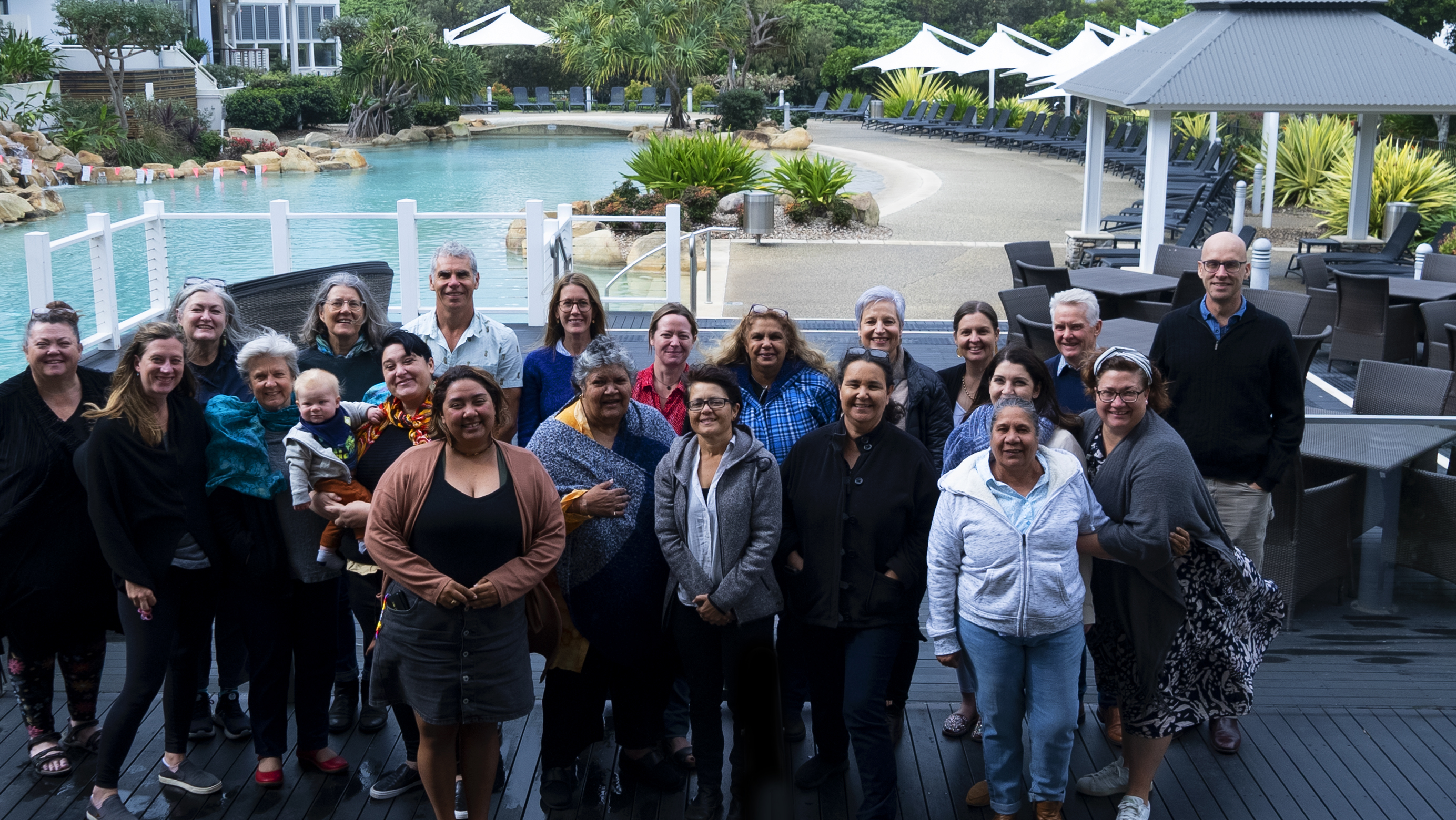 A group of 22 people outside smiling