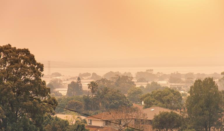 orange bushfire smoke haze over housing
