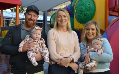 Associate Professor Alice Rumbold standing with two adults who are holding young babies.