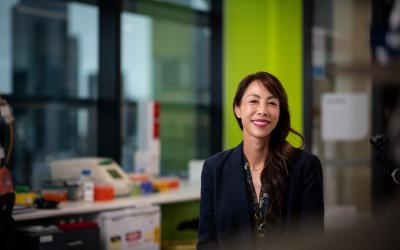 Professor Sherene Loi smiling and sitting down in a labratory