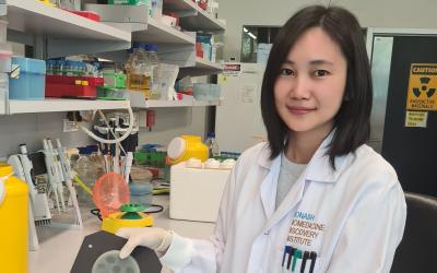 Dr Sue Chin Nang in a laboratory holding a petri dish